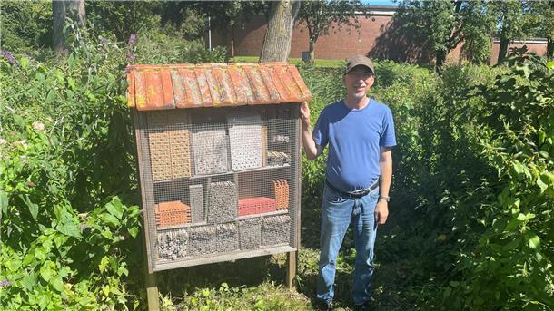 Mann neben Insektenhotel