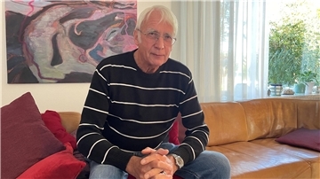 Mann sitzt auf Sofa