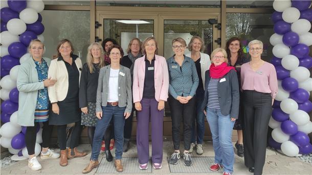 Geschäftsführung und Mitarbeitende stehen vor dem Eingang des neuen PBW-Standort in der Postbrookstraße 91 in Bremerhaven