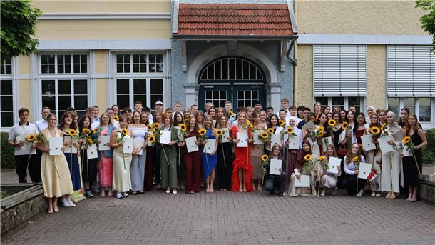 Junge Leute mit Sonnenblumen in den Händen. Es handelt sich um die Abiturienten des Nordenhamer Gymnasiums.