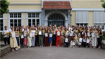 Junge Leute mit Sonnenblumen in den Händen. Es handelt sich um die Abiturienten des Nordenhamer Gymnasiums.
