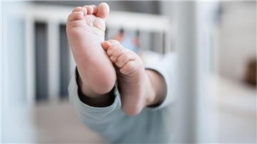 Die Füße eines Babys sind in einem Kinderbett zu sehen. Gesundheitswissenschaftler Lars Timm hat vorgeschlagen, alle Geburten in der Region in Bremerhaven zu konzentrieren. 