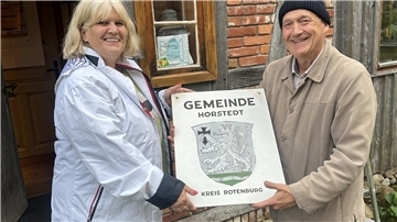 Gina Sojka und Michael Schröck mit dem Gemeidewappen.