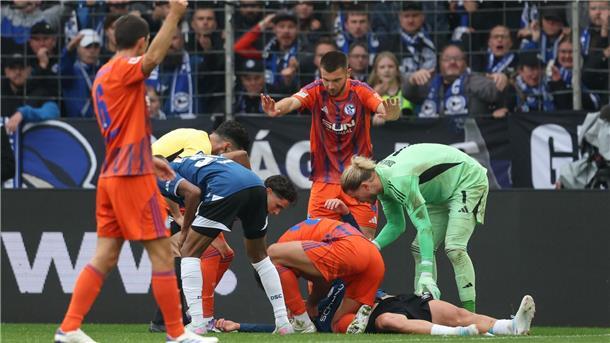 Schalker Abwehrchef hilft bewusstlosem Gegner Grodowski liegt auf dem Rasen.