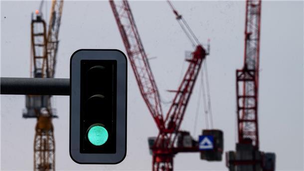 Grüne Ampel vor Kränen am Alexanderplatz in Berlin.