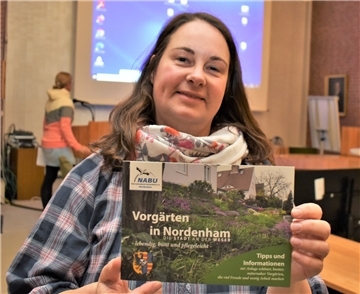 Grünen-Ratsmitglied Inga Lüdke zeigt die Broschüre, die Tipps für naturnahe Vorgärten gibt.