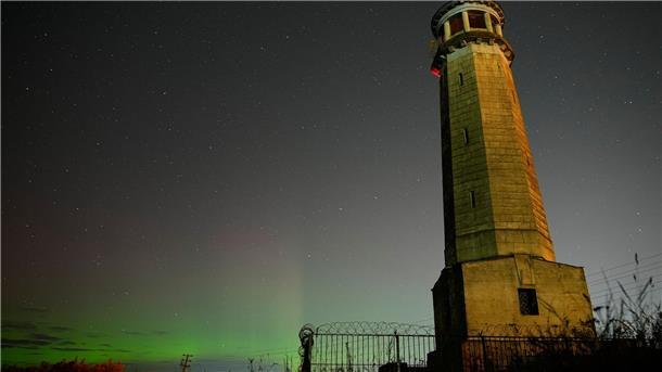Bilder des Tages Grünlich schimmern die Nordlichter am Nachthimmel.