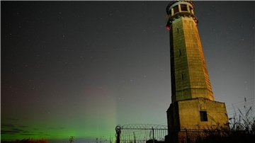 Bilder des Tages Grünlich schimmern die Nordlichter am Nachthimmel.