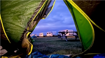 Guten Morgen, Sylt! Aus dem Zelt blickt unsere Autorin auf ein typisches Campingplatz-Ensemble: Picknicktisch, Wohnmobile und andere Zelte.