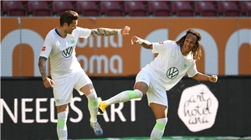 Haben die Abstandsregeln beim Torjubel eingehalten: Wolfsburgs Daniel Ginczek (l) feiert sein Tor zum 1:2 mit Wolfsburgs Kevin Mbabu.