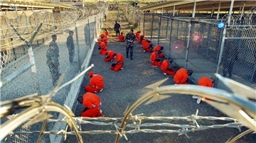 Häftlinge knien im Camp X-Ray des US-Marinestützpunkts Guantánamo Bay auf Kuba auf dem Boden (Archivbild).
