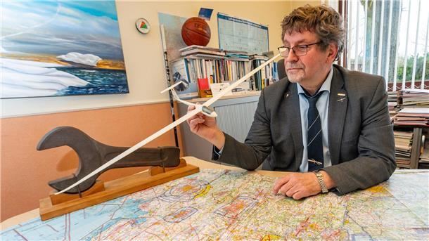 Ein Mann hat ein Modell eines Segelflugzeugs in der Luft. 