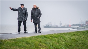 Zwei Männer stehen auf dem Deich in Bremerhaven.