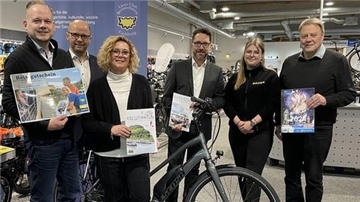 Sechs Personen und ein Fahrrad in einem Geschäft.