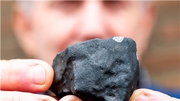 Hausbesitzer Wilfried Labusch mit einem kleinen Meteoriten, der niedergegangen ist.