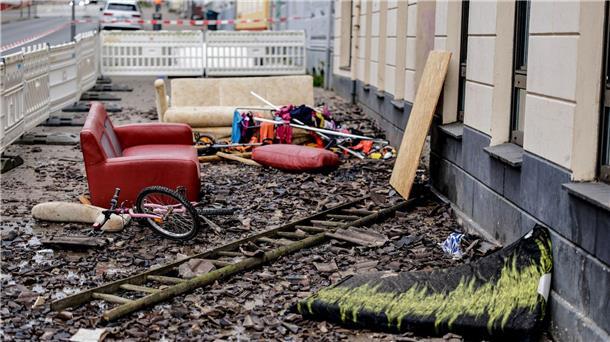 Hausrat und ein Fahrrad liegen in der Flensburger Neustadt an dem Mehrfamilienhaus in den Überresten des Feuers.
