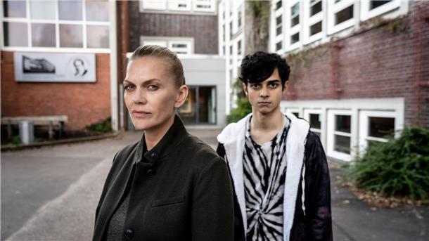Helen Dorn (Anna Loos) trifft Denniz Burhan (Dominik Ganser) auf einem Schulgelände.