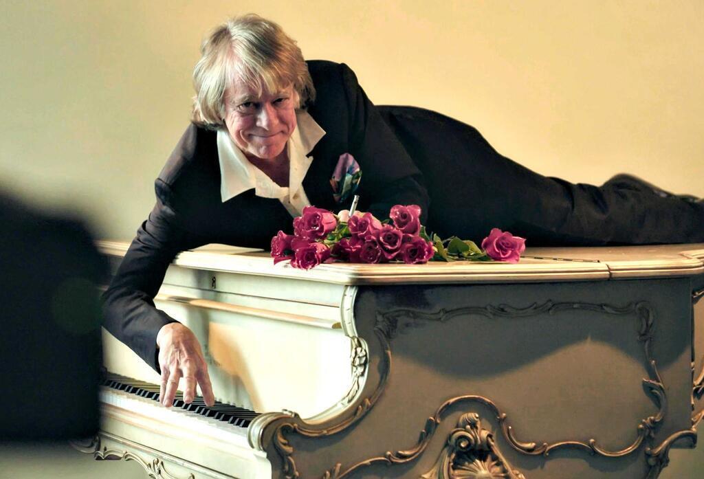 Helge Schneider liegt auf einem Klavier in einer Szene des Films „Helge Schneider - The Klimperclown“, der nun in der Mediathek zu sehen ist und am Mittwoch, 20.8., im Ersten gezeigt wird.
