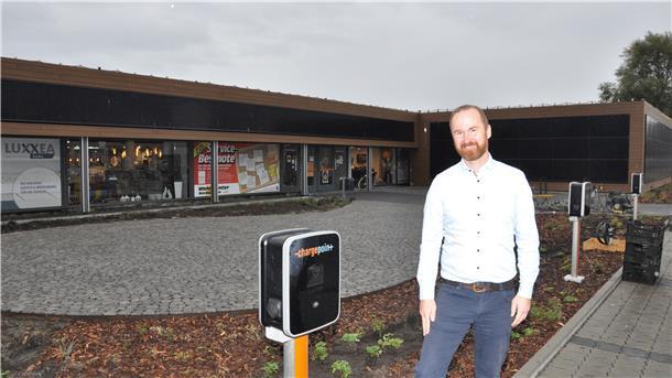 Hendrik Lenz, Inhaber des Wohncenters, vor einigen von insgesamt 20 geplanten Ladesäulen für Elektroautos rund um seinen Parkplatz.
