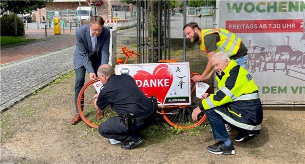 Henning Fricke, Rolf Meyer, Niklas Breden und Johannes Fuhr bei der Montage des ersten Rades und gemeinsam mit Pia Kostbade beim Aufsprühen der Piktogramme in Zeven.
