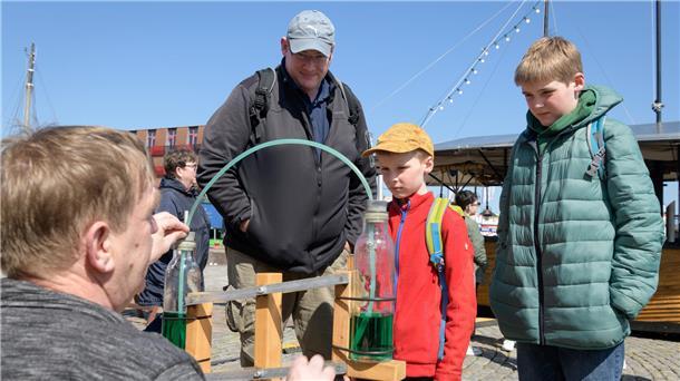 Herbert Schulze ließ sich auf der Fischparty mit seinen Söhnen Johannes (7) und Theodor (11) von Experimenten des Phänomenta-Standes begeistern. Foto: Masorat-f