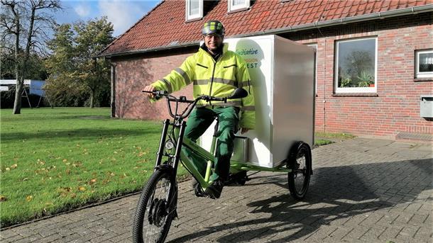 Ein Mann sitzt auf einem E-Lastenrad.