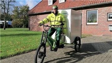 Ein Mann sitzt auf einem E-Lastenrad.
