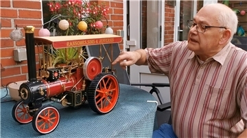Hier erläutert Rolf Becker, wie sein Traktor im Miniaturformat funktioniert. Das Fahrzeug wird nicht mit Dampf, sondern mit Strom betrieben.