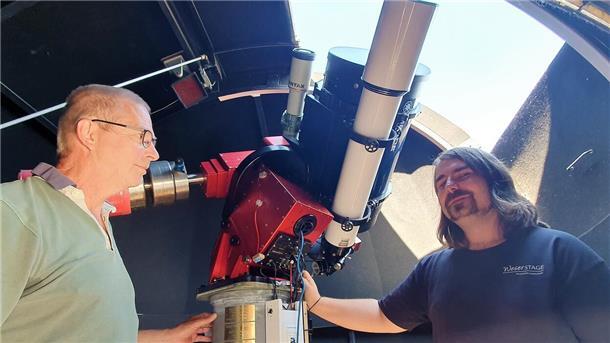 Hier kann man auch beobachten: Julian Wesch (rechts) und Dr. Jens-Peter Jacobsen erläutern die Teleskope in der Kuppel des Observatoriums auf dem Mehrzweckgebäude des NIG, die die Sonne und damit das Zentrum des künftigen Planetenpfades darstellen soll.