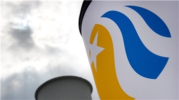 Hinter einem Vattenfall-Logo ist im Stadtteil Lichterfelde in Berlin ein Abgasturm des Heizkraftwerkes der Vattenfall Europe AG zu sehen.