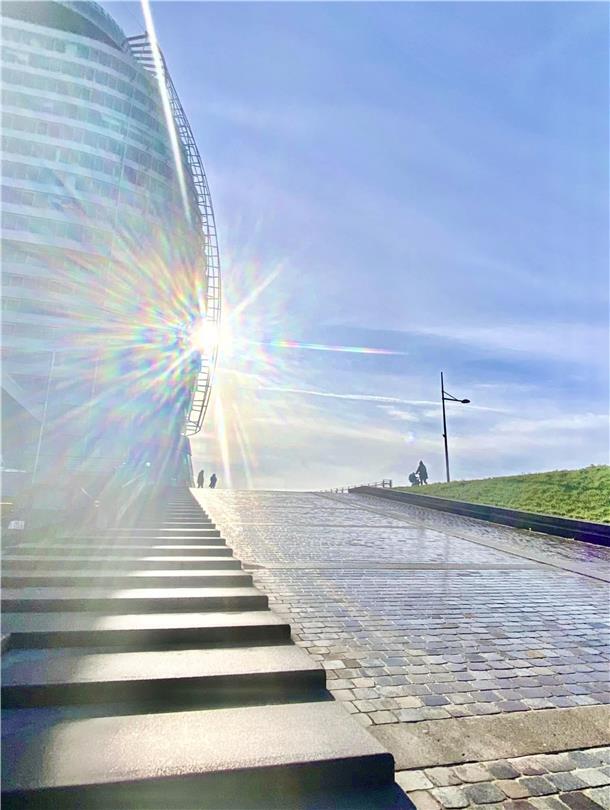 Da Vincis Gestirne und mein Hoffen auf irdische Sterne mit zwei Augen und Armen Horizonte. Lichtblicke. Wege. Die Sonne als gleißendes Gestirn über Rampe und Treppe unter dem Bremerhavener Atlantic Sail City hinauf zum Deich hat Symbolkraft.