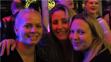 Drei Frauen lächeln in die Kamera.