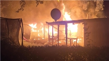 Flammen schlagen aus einer brennenden Kleingartenparzelle