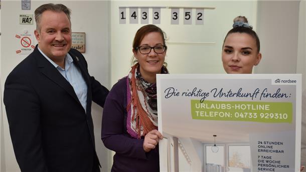 Im Büro der Zimmervermittlung in Burhave mit der aktuellen Umsatzzahl oben an der Tür: Geschäftsführer Robert Kowitz, Leiterin Jana Müller und Mitarbeiterin Kitana Petz  (von links).