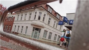 Ein Gebäude aus der Gründerzeit, davor ein Spielgerät aus Metall.