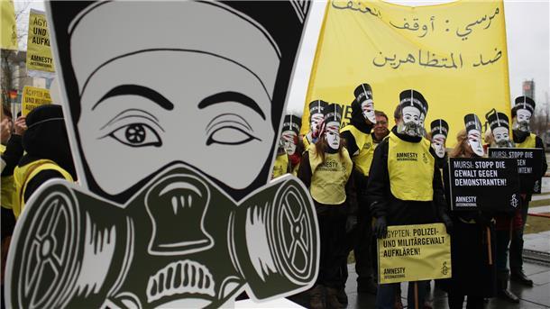 Demonstranten mit einer Figur der Nofretete in Berlin