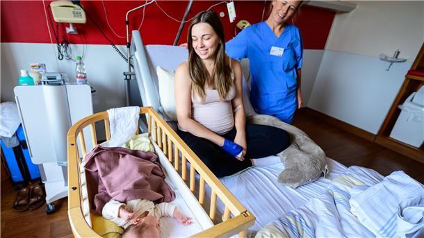Kreißsaal zum Wohlfühlen: zwei Hebammen bei der Geburt Im Klinikum Lüneburg werden Verena Ahrens und ihre wenige Tage alte Tochter von Hebamme Franziska Pfeil (r) betreut. Frauen können dort seit diesem Monat in Begleitung von zwei Hebammen entbinden.