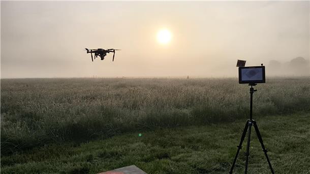 Kitzrettung in den frühen Morgenstunden  Im Morgennebel steigt eine Drohne über eine Wiese auf, die gleich gemäht werden soll.
