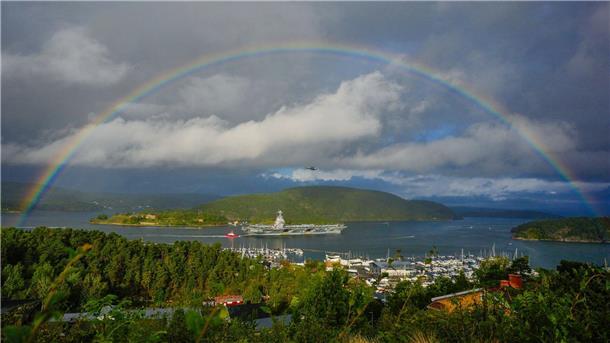 Im Oslo-Fjord fährt ein amerikanisches Kriegsschiff unter einem Regenbogen hindurch.