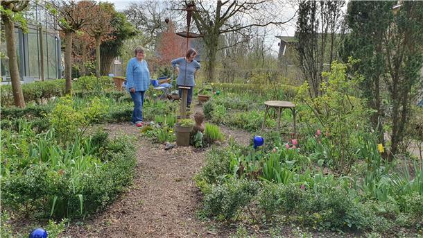Im privaten Garten hinter dem Dorumer Glashaus blüht es im April schon wieder prächtig. Andrea Prieß (links) und Bewohnerin Barbara Mohrmann genießen das gute Gärtnerwetter und wünschen sich nur eines: „Regen“.