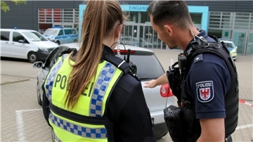 Beamte von der Bremerhavener Polizei (links eine Frau, rechts ein Mann) kontrollieren ein Fahrzeug. Im Rahmen der Aktion „Drogen im Straßenverkehr“ kontrollierten Polizei, Zoll und Partner über 260 Personen – mit deutlichen Ergebnissen.