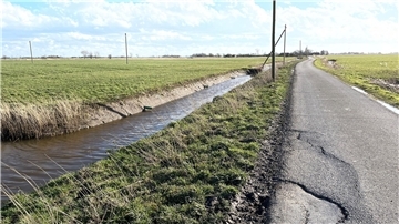 Ein Graben verläuft neben einem Wirtschaftsweg in Butjadingen