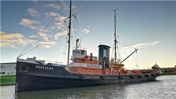 Der historische Bergungsschlepper „Seefalke“ liegt im Museumshafen des Deutschen Schifffahrtsmuseums in Bremerhaven, umgeben von ruhigem Wasser und Abendlicht.