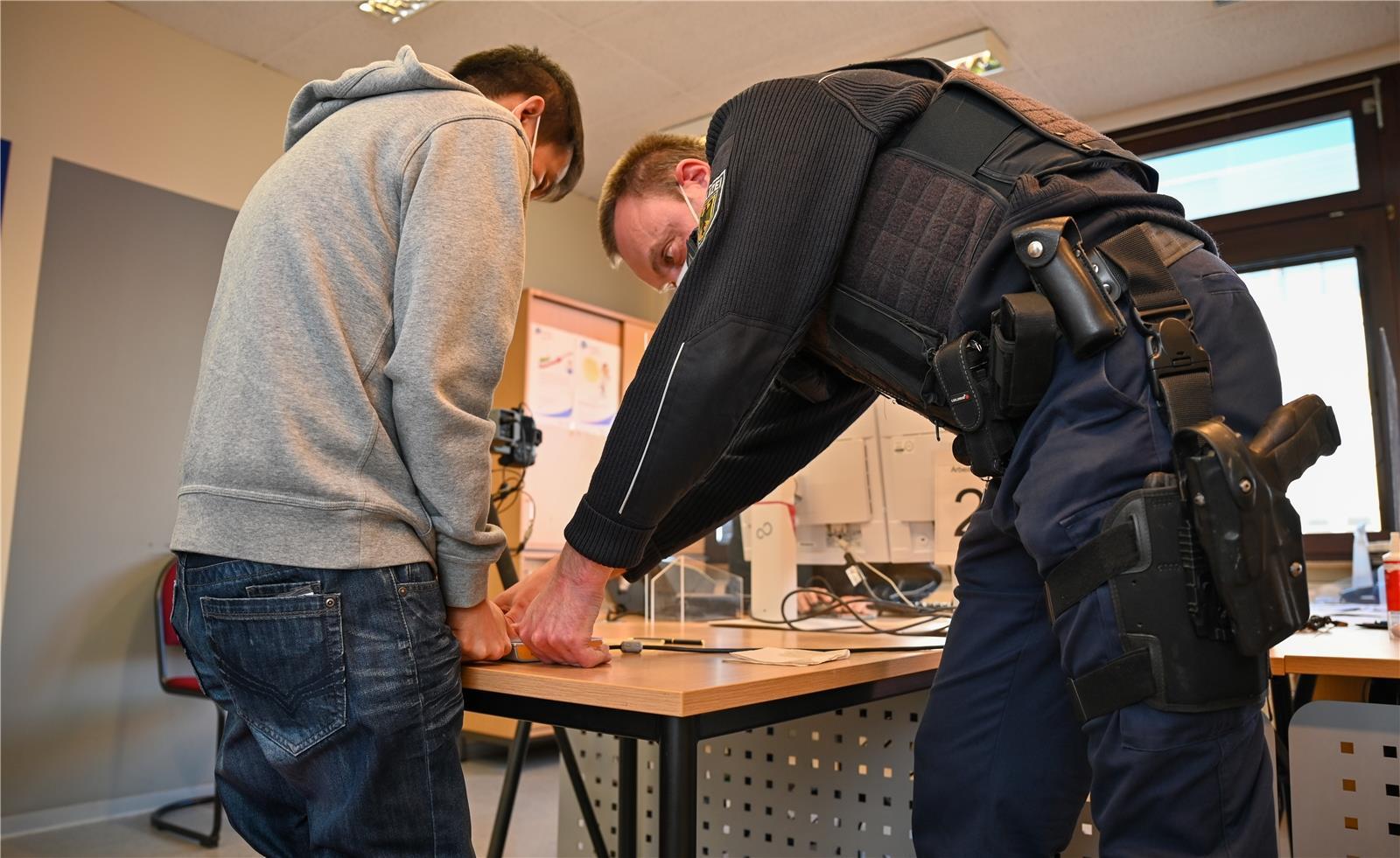 Im Revier nimmt René Schmidt nimmt Fingerabdrücke von einem Crew-Mitglied. Er br...