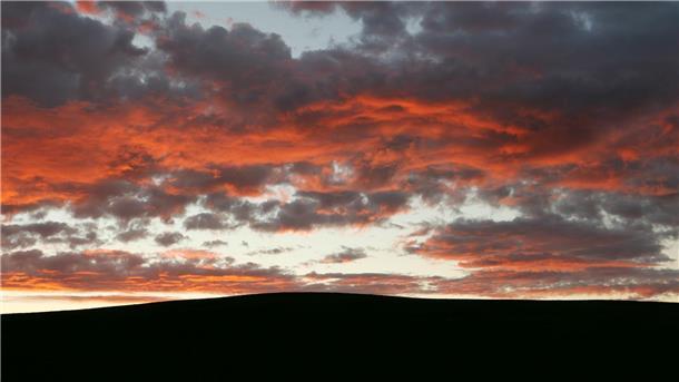 Bilder des Tages Im Sonnenaufgang leuchten die Wolken rötlich.
