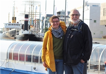 Eine Frau und ein Mann stehen am Hafen.