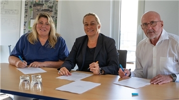 Zwei Frauen und ein Herr (rechts) sitzen an einem Tisch und unterzeichnen Dokumente. Im St. Bernhard-Hospital Brake wurde die Kooperation mit Evidia für die radiologische Versorgung offiziell verlängert: Sabine Busche (Geschäftsführerin Evidia MVZ Radiologie Jade-Weser), Selma Heinrich (CEO Evidia Germany) und Frank Germeroth (St. Bernhard Hospital Brake).