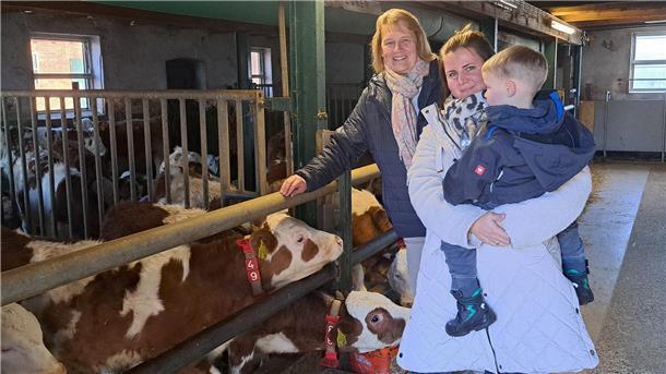 Britta Grollimund vom Landvolk und Landwirtin Annkathrin Thalmann mit Sohn im Stall mit den Kälbern. 