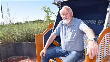 Udo Venema, Pächter der Weserterrassen, sitzt im Außenbereich des Restaurants in einem Strandkorb.
