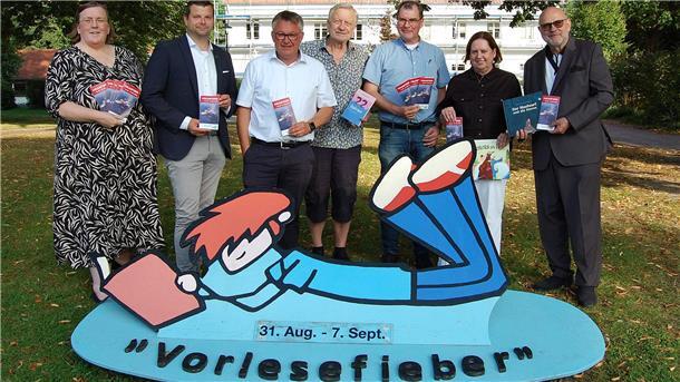 Gemeinsam lesen, gemeinsam träumen: Das Vorlesefieber in Hagen Männer und Frauen haben sich mit Programmheften in der Hand zu einem Gruppenfoto aufgestellt.